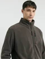 Campera de micropolar color marrón, con cuello alto, cierre frontal completo y bolsillo con cierre en el pecho.