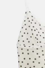 Top de tul blanco con estampado de lunares negros, escote en V y tirantes finos ajustables.