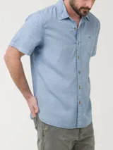 Camisa celeste de manga larga RKF Galiton, confeccionada en popelina 100% algodón orgánico. Cuenta con botones de madera, mangas ajustables, bolsillo de pecho con logo bordado y protección UPF +20.
