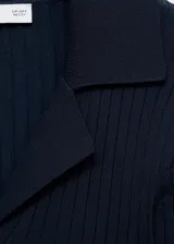 Cardigan de punto fino acanalado, color negro, con cuello en V con solapa y cierre frontal de botones.