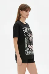 Remera de algodón color marfil, de corte holgado y mangas cortas, con cuello redondo y estampado frontal de diseño inspirado en la música con texto "The Endless County Keep On Rocking" y detalles de girasoles.