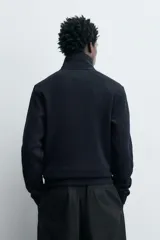 Chaqueta regular fit de cuello subido, confeccionada en tejido técnico interlock de algodón con elasticidad. Presenta cierre frontal con cremallera, manga larga con puños en rib y bolsillos de vivo en la cadera.