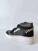 Zapatillas deportivas de caña alta con estampado de piel de reptil en tonos verde y negro, detalles en blanco y suela gruesa blanca.