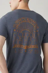 Remera azul de manga corta con cuello redondo y estampado pequeño en el pecho.