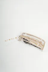 Necessaire transparente de PVC con cierre y bordes en color beige, ideal para guardar artículos pequeños de maquillaje o cuidado personal.