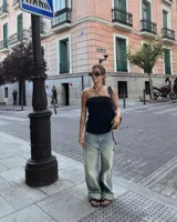 Collar con dije de forma irregular en tonos dorados y plateados, suspendido de un cordón doble de algodón negro.