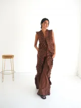 Pantalón largo de lino color marrón, con apliques de tablas cosidas en los laterales que crean textura y movimiento, y tajos laterales.