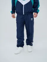 Pantalón de jogging Umbro color azul marino, de corte recto, con cintura elástica y líneas blancas decorativas a los laterales. Presenta el logo de la marca bordado en blanco en la pierna izquierda.