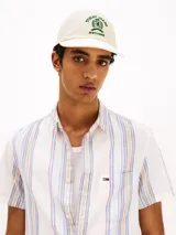 Gorra de béisbol color crema con logo bordado en verde en el frente.