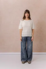 Jean de tiro medio con calce wide leg y pierna amplia, confeccionado en denim azul con estampado floral tono sobre tono. Cuenta con bolsillos delanteros y traseros, y cierre frontal con botón y cremallera.