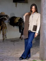 Campera de lana color crudo con cierre frontal, cuello alto y bolsillos frontales en contraste color marrón. Presenta un diseño estructurado con espalda en paño.