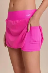 Conjunto deportivo compuesto por una pollera short y un top, ambos en color verde menta. La pollera tipo short cuenta con laterales redondeados, bolsillo en la cintura y short interno con bolsillo lateral. El top presenta diseño clásico con escote redondo y tirantes finos.