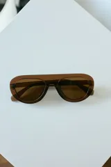 Lentes de sol con armazón de policarbonato color marrón traslúcido y diseño envolvente de una sola pieza.
