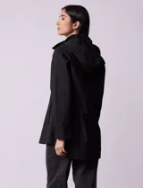 Campera impermeable color gris claro, marca Gallery. Tiene abertura central con cierre oculto y botones a presión, bolsillos delanteros y capucha plegable en el cuello.