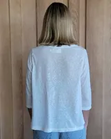 Blusa blanca de lino con escote en V y mangas 3/4.