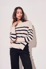 Sweater beige con rayas horizontales negras, de corte holgado y mangas largas.