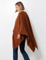 Ruana de tejido soft, color marrón óxido, de corte amplio y sin cierres, con cuello redondo.
