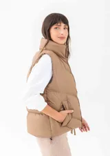 Chaleco puffer negro con cuello alto, cierre frontal y bolsillos laterales.