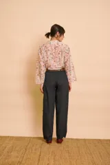 Pantalón de lino color negro, de corte relajado, con bolsillos frontales tipo parche y cintura elástica. Incluye un cinturón de cuero marrón con hebilla metálica.