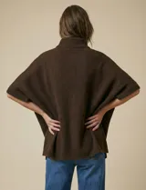 Capa tejida color fucsia, con cuello alto abotonado y mangas cortas estilo japonesa. Tejido de punto grueso.