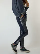 Pantalón marrón con laminado metalizado dorado, cintura elastizada y corte ajustado.