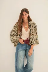 Kimono de corte holgado con estampado animal print tipo tigre, con bordes frontales decorados con pedrería y bordados artesanales. Presenta mangas anchas y forro interior.