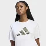 Remera Adidas de corte clásico y cuello redondo, confeccionada en tejido de punto jersey de algodón. Presenta un estampado frontal con el logo de la marca en diseño de camuflaje multicolor.