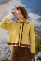 Cardigan de punto color amarillo mostaza con cuello Peter Pan tejido a mano en crochet marrón, cierre frontal de botones y detalles en marrón y crudo en los puños, cuello y ruedo con terminación de ondas.