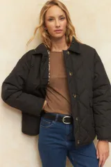 Campera capitoneada negra con botones veteados, bolsillos laterales de solapa y forro de satén con estampado animal print.