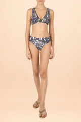 Top de bikini con escote en V profundo, diseño de estampado orgánico en tonos verde y violeta sobre fondo blanco, con ribetes en color verde oliva.