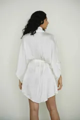 Bata color crema confeccionada en seda, con lazo de ajuste en la cintura.