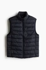Chaleco acolchado negro con cuello alto, cierre frontal con cremallera y bolsillos laterales con cremallera.