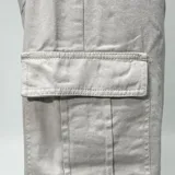 Pantalón cargo de jean color hueso, de corte ultra baggy con bolsillos laterales en las piernas.