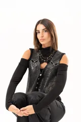 Chaleco de cuero con acabado desgastado, estilo western, con cierre frontal de botones metálicos y detalles de ojalillos con entrelazado de cuero en la parte superior delantera.