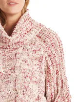 Buzo tejido en punto aran con cuello volcado y mangas largas con puño. Presenta un diseño jaspeado en tonos rosados y beige.