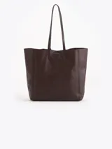Cartera tipo shopper Jazmin Chebar modelo Honey, color negro, confeccionada en cuero vacuno suave. Cuenta con amplia capacidad, doble asa larga para el hombro y diseño grabado con abejas en bajo relieve. Incluye un tag colgante decorativo con dije metálico en forma de abeja.