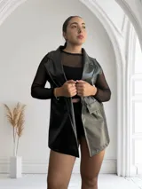 Chaleco largo negro con textura símil piel de reptil y corte sastrero.