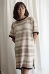 Vestido tejido a rayas horizontales en tonos beige y marrón, con cuello redondo y mangas cortas con ribete negro.