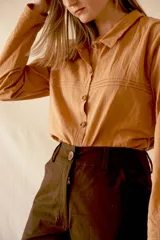 Pantalón marrón de gabardina elastizada, tiro alto, corte wide leg y botones de coco.