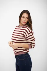 Buzo de tejido de punto con diseño a rayas horizontales en color bordó y beige, de cuello redondo, manga larga y puños y ruedo acanalados.