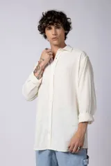 Camisa de manga larga confeccionada en lino, color verde oliva, con cuello clásico y cierre frontal de botones.