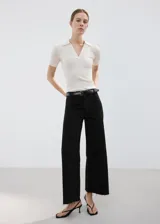 Jeans wide leg negros de tiro medio, con diseño de pernera ancha y terminación desmechada en el bajo.
