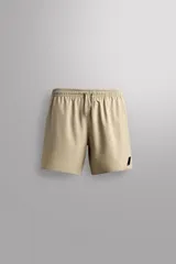 Pantalón corto deportivo color beige, confeccionado en tejido técnico ligero y elástico, con forro interior. Presenta cintura elástica ajustable con cordón, bolsillos frontales, bolsillo de seguridad trasero con cierre y aberturas laterales en el bajo.