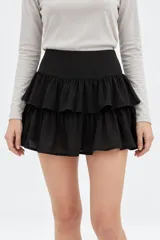 Minifalda blanca de viscosa con diseño de doble vuelo y volados horizontales.