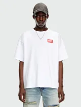 Remera blanca de corte holgado con cuello redondo y manga corta. Presenta un pequeño parche rectangular rojo con el logo de Diesel en el pecho.