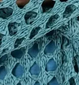 Top tejido al crochet color celeste, con escote en V y mangas largas acampanadas.