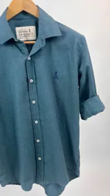 Camisa de manga larga verde petróleo con cuello italiano y logo bordado en el pecho.
