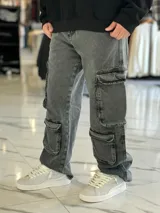 Pantalón de jean estilo cargo, color azul, de corte ancho y holgado, con múltiples bolsillos laterales en muslos y pantorrillas.
