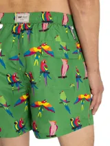 Short de baño verde RKF confeccionado con poliéster reciclado, con estampado de loros y aves coloridas en todo su diseño. Cuenta con cintura elástica, cordón ajustable en color gris y bolsillos laterales.