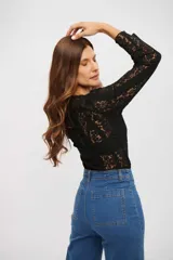 Top de encaje negro de manga larga, con diseño ajustado y cuello redondo.